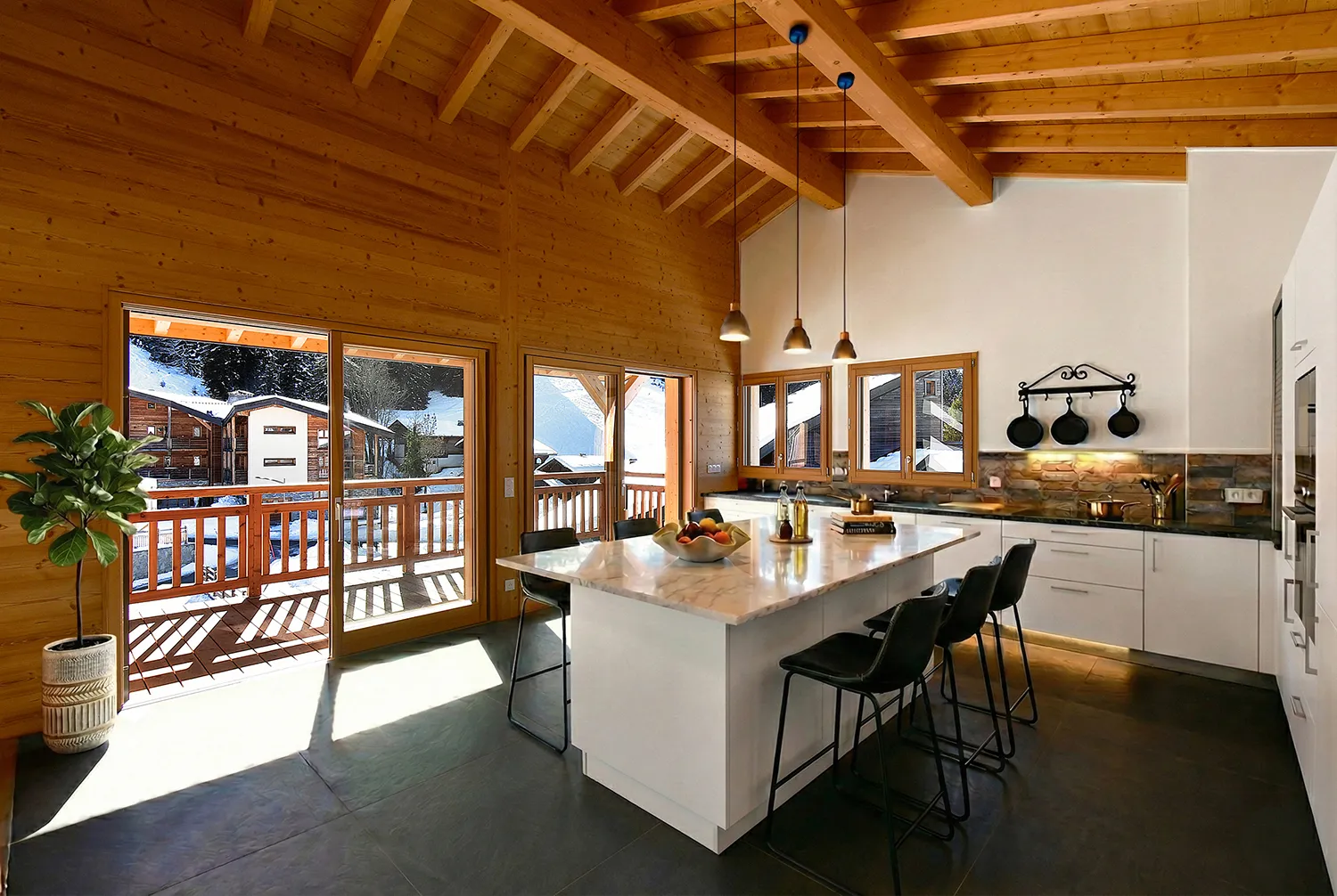 Cuisine de chalet avec îlot meublée en home staging virtuel, balcon et vue enneigée
