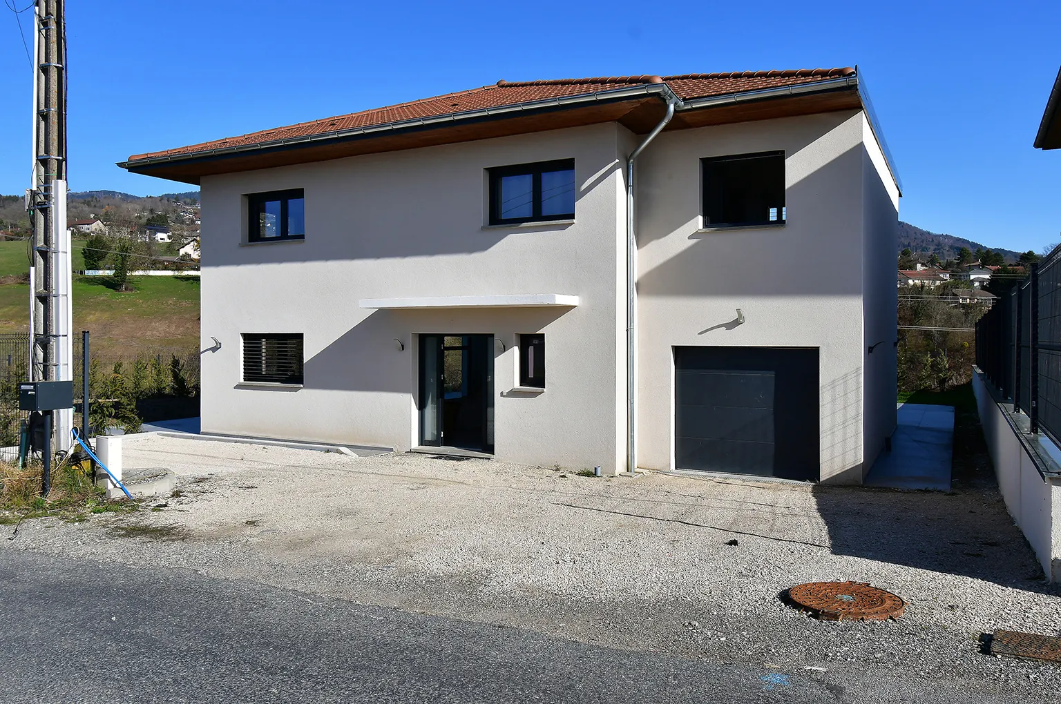 Façade de maison neuve avant retouche, abords non aménagés